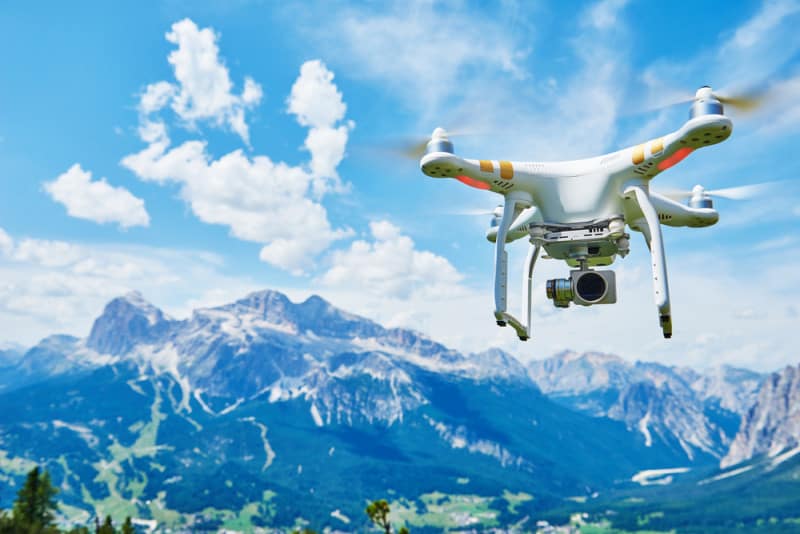 Flying innovative drone set against a mountain
