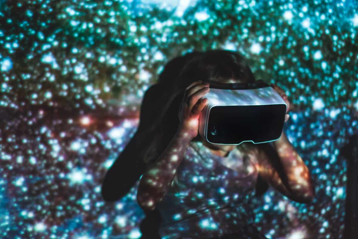 Girl using virtual reality headset surrounded by colours