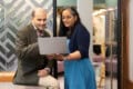 Karim Budabuss and Shyla Sudhir talking and looking at a laptop.