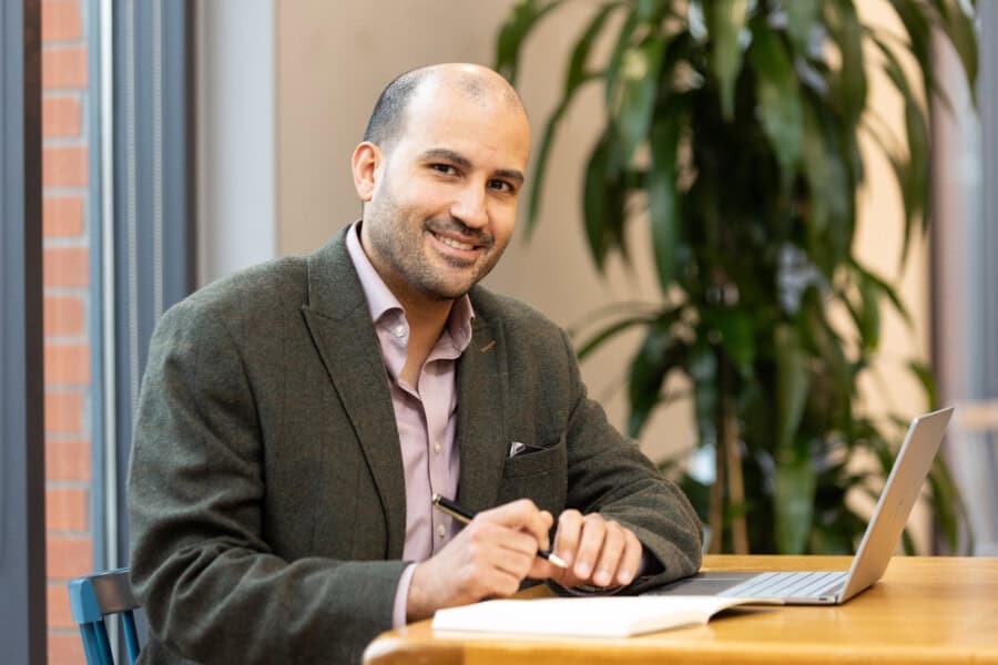 Karim Budabuss sitting at a table with a laptop