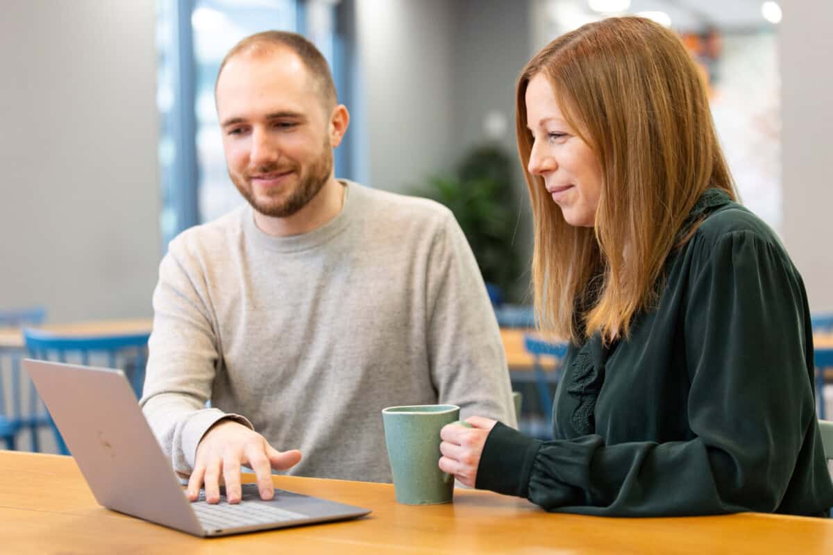 ForrestBrown team members Isaac Greenbury and Kelly Oakley working at a laptop.