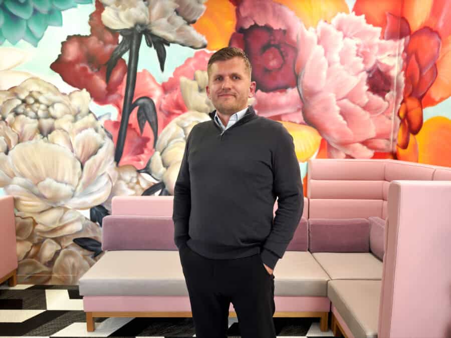 Picture of Tom McDanell, Managing Director at ForrestBrown, against a floral mural backdrop.